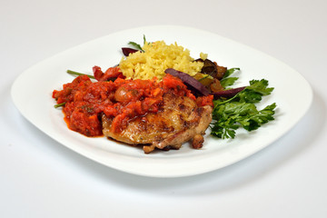 Food from a chicken restaurant with vegetables and sauce.