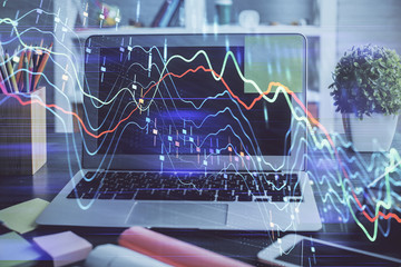 Financial chart drawing and table with computer on background. Double exposure. Concept of international markets.