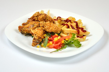 Food from a chicken restaurant with vegetables and sauce.