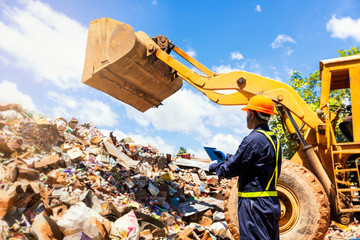 Crane operator. The engineer is controlling the loader to get the iron to recycle. Worker standing...