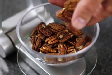 Weighing Pecan Nuts on Kitchen Scale. Making Chocolate, Pear and Pecan Pie Series.