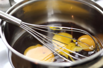 Eggs and melted chocolate in saucepan. Making Chocolate, Pear and Pecan Pie Series.