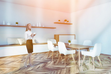 Blonde woman in white dining room with cabinet