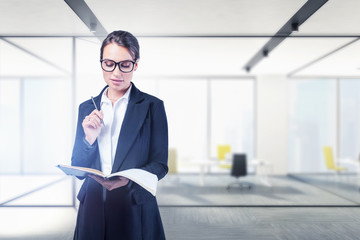 Businesswoman with glasses and notebook in office