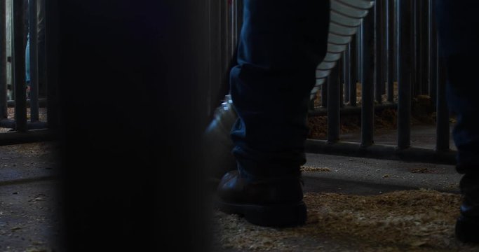 Worker cleaning an animal pen area using an industrial vacuum machine