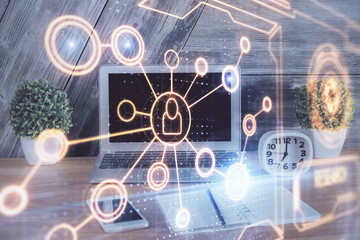 Computer on desktop with social network hologram. Multi exposure. Concept of international people connections.