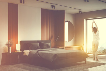 Woman in white and wooden bedroom with mirror