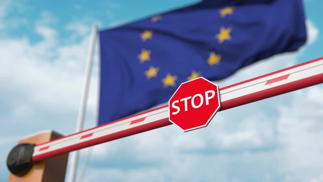 Barrier gate being closed with flag of the EU as a background. European restricted entry or certain ban