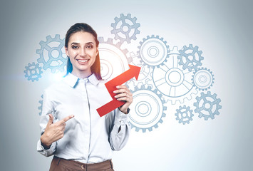 Woman pointing at graph and gears as team