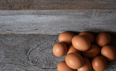 Top view chicken eggs on the old wood with a wooden wall in the background.