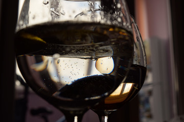 glass of water with and drops of oil