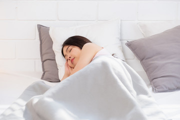 Obraz na płótnie Canvas asian woman sleeping on white bed with blanket in bedroom at morning