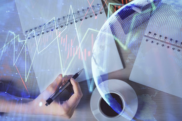 Multi exposure of woman's hands making notes with forex graph hologram. Concept of technical analysis.