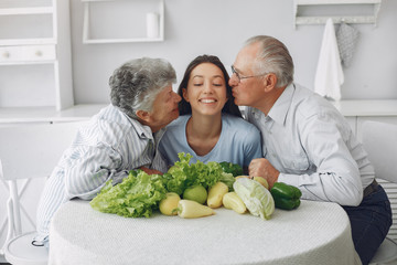 Family in a kitchen. Grandparents with granddaughter. Family made a salad