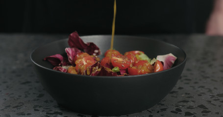 man preparing salad adding oil