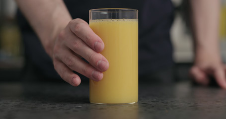 man takes glass with orange juice