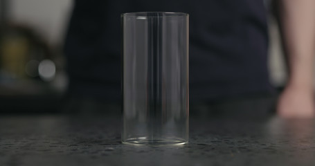 empty glass on terrazzo countertop with man on background