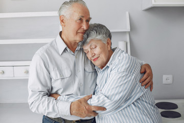 Old couple in a room. Grandparents at home. Woman in a whire whirt