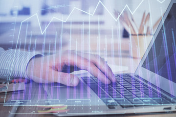 Double exposure of stock market graph with man working on laptop on background. Concept of financial analysis.