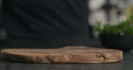 empty olive wood cutting board on terrazzo surface