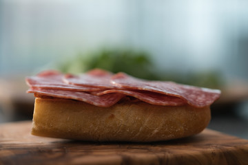 Toasted ciabatta with salami sausage on olive board