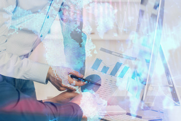 Fototapeta premium Double exposure of chart with businessman typing on computer in office on background. Concept of hard work.