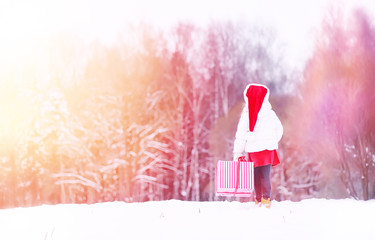 A winter fairy tale, a young mother and her daughter. A girl on a sled with gifts on the eve of the new year in the park. Two sisters walk in a New Year's park and ride a sled with gifts.
