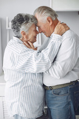 Old couple in a room. Grandparents at home. Woman in a whire whirt