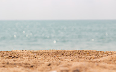 Close up surface of sand on the beach and blur foreground and blur bokeh sea background