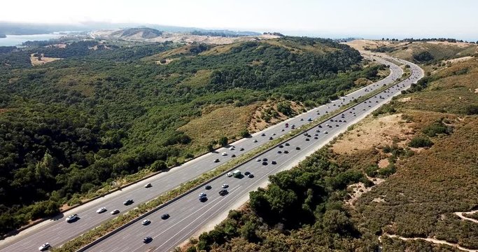 Highway traffic on a Summer afternoon with Fog Rolling over Crystal Springs Reservoir as seen from a vista point