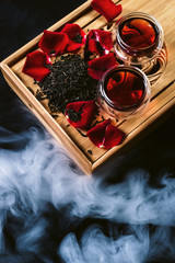 Chinese tea ceremony. Still life with traditional Asian Yunnan black tea, red tea in classic cups and rose petals as symbol of flower flavor of drink