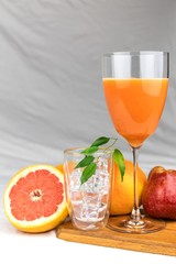 Fresh juice of red grapefruit with apples on white cloth. Diet drink. Homemade juice. Glass with drink.