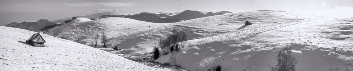 the rays of the sun over the mountains with snow and old derelict hut, Cindrel mountains, Paltinis,...