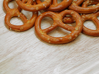close up of salty crispy cracker mini pretzels on wooden table background with copy space