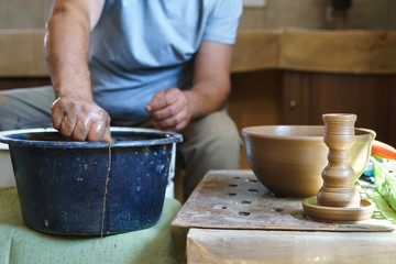 Fototapeta na wymiar Clay candlestick on background of working potter.