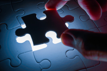 Missing piece of jigsaw puzzle with light glow, business concept for completing the final puzzle...