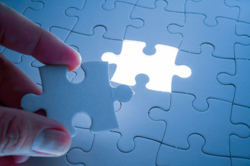 Missing piece of jigsaw puzzle with light glow, business concept for completing the final puzzle piece