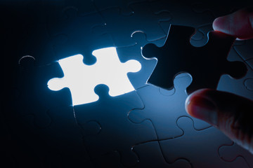 Missing piece of jigsaw puzzle with light glow, business concept for completing the final puzzle...
