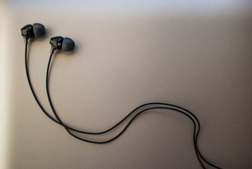Black earphones on silver background