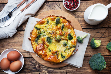 Baked omelet with broccoli on a wooden Board and background. Healthy diet food dish.