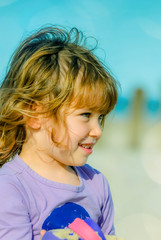 Portrait of a pretty little girl playing on the beach