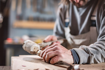 Carpenter working on a old wood in a retro vintage workshop.
