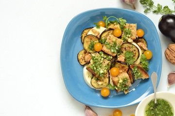 Eggplant with mozzarella, croutons, cilantro pesto and walnuts, top view, copy space
