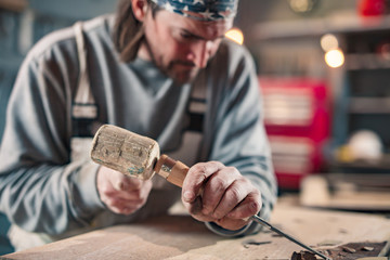 Carpenter working on a old wood in a retro vintage workshop.