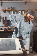 Carpenter working on the old wood in a retro vintage workshop.