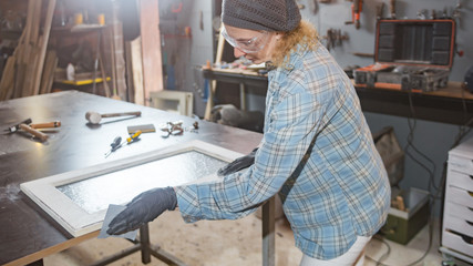 Carpenter working on the old wood in a retro vintage workshop.