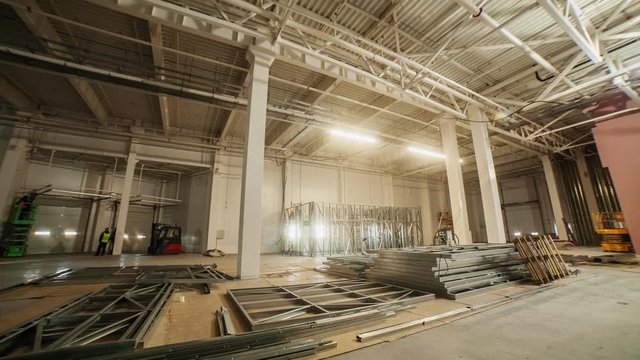 workers with scissor lift assemble racks in warehouse
