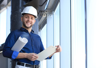 Shot of male architect wearing hardhat and inspecting new building.
