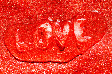 LOVE message for Valentine's Day in ice letters melting on passionate sparkling red background