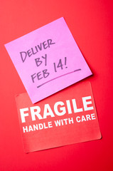 Bright red package with Fragile sticker and Deliver by Feb 14! message